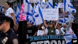 Protesters wave flags and chant slogans near the site of a meeting between President Joe Biden and Israeli Prime Minister Benjamin Netanyahu in New York, Sept. 20, 2023.