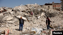 Hasan Arslan, and his wife, Havva, visit what's left of their home, where they were trapped with his three children for five days until being rescued in the aftermath of a deadly earthquake in Nurdagi, Turkey, March 4, 2023.