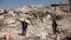 Hasan Arslan, and his wife, Havva, visit what's left of their home, where they were trapped with his three children for five days until being rescued in the aftermath of a deadly earthquake in Nurdagi, Turkey, March 4, 2023.