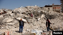 Hasan Arslan, and his wife, Havva, visit what's left of their home, where they were trapped with his three children for five days until being rescued in the aftermath of a deadly earthquake in Nurdagi, Turkey, March 4, 2023.