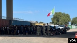 ARCHIVO - Autoridades fronterizas agrupan a migrantes irregulares que se entregaron para ser procesados tras cruzar a Eagle Pass, Texas, el 29 de septiembre de 2023. (Salomé Ramírez, VOA)