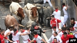 Participants run ahead of Jose Escolar Gil breeder fighting bulls during the seventh bull run of the San Fermin festival in Pamplona, Spain, July 13, 2024.
