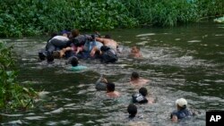 Migran travese rivye Rio Bravo a pou antre Ozetazini depi Matamoros, Meksik, Madi 9 Me, 2023. 