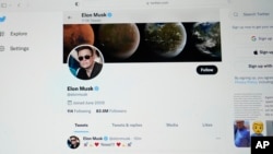 FILE - The Twitter page of Elon Musk is seen on the screen of a computer in Sausalito, California, April 25, 2022. The EU says that letting users pay for a blue check - formerly a sign the account was verified - violates its Digital Services Act.