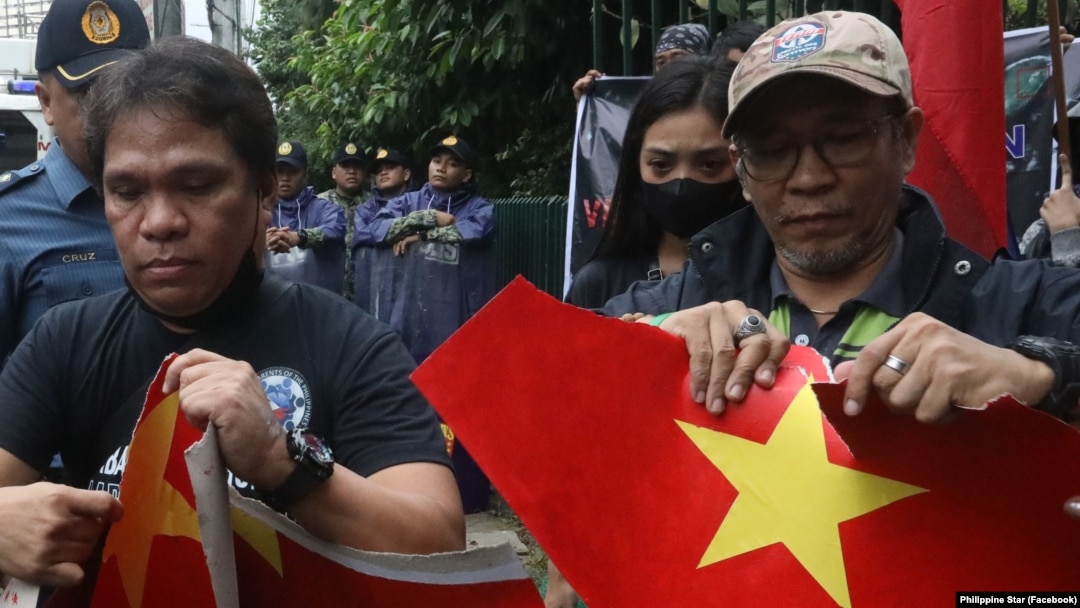 Các thành viên nhóm Makabansa của Philippines xé giấy in hình cờ đỏ sao vàng của Việt Nam khi biểu tình trước cửa Đại sứ quán Việt Nam ở Manilia, Philippines, vào ngày 1/8/2023.