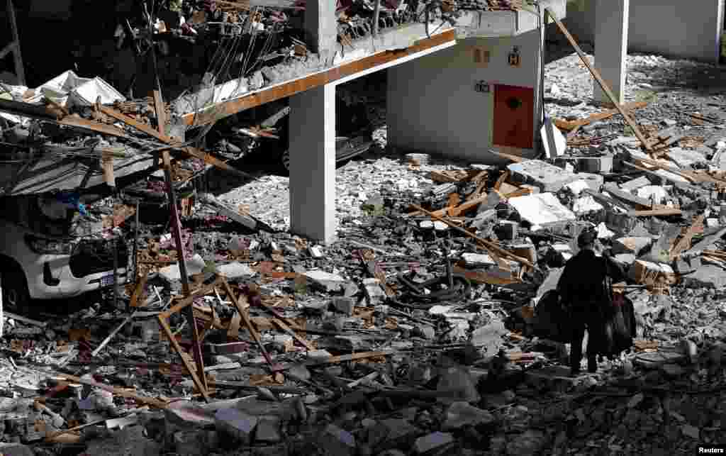 A man carrying his belongings leaves a damaged building after a gas blast in Campos do Jordan, in Sao Paulo state, Brazil, April 23, 2023.