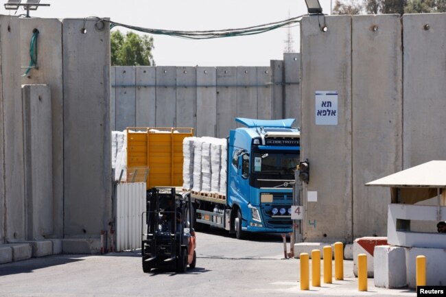 Sebuah truk membawa bantuan kemanusiaan tujuan Jalur Gaza, di tengah konflik yang sedang berlangsung di Gaza antara Israel dan Hamas, di penyeberangan Kerem Shalom di Israel selatan, 10 Juli 2024. (Foto: Amir Cohen/Reuters)