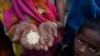 FILE - A woman from an impoverished family shows the sample of rice which she received under a government plan offering free ration, on the outskirts of Patna, in the Indian state of Bihar, on May 11, 2024.