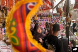 Warga membeli lampion dan dekorasi tradisional di pasar Sayyeda Zeinab menjelang bulan Ramadan, di Kairo, Mesir, Selasa, 21 Maret 2023. (AP/Amr Nabil)