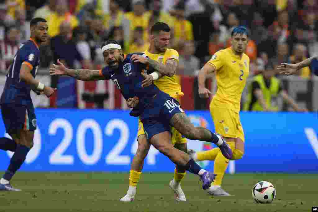Memphis Depay of the Netherlands (10) is challenged by Romania&#39;s Marius Marin during a round of sixteen match between Romania and the Netherlands at the Euro 2024 soccer tournament in Munich, Germany.