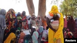 FILE - Masalit women gather under a neem tree to share stories about the deaths of their children and family members, mostly male, at a refugee camp in Adre, Chad November 12, 2023.