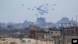 (FILE) An aircraft airdrops humanitarian aid over the northern Gaza Strip, as seen from central Gaza, April 30, 2024.