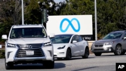 Cars drive past a Meta sign outside of the company's headquarters in Menlo Park, Calif., March 7, 2023.