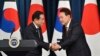 South Korean President Yoon Suk Yeol, right, shakes hands with Japanese Prime Minister Fumio Kishida during a joint press conference after their meeting at the presidential office in Seoul, May 7, 2023.