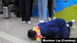 台商李孟居9月2日抵达台湾机场，重获自由时激动趴下、亲吻“自由的土地”（美国之音特约记者李贤摄影）。