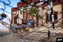 Raseljena palestinska devojčica sedi na ljuljašsci u Rafi, 15. maja 2024.