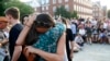Dos personas se abrazan mientras se reúnen para una vigilia en respuesta a un tiroteo fatal en la sala de redacción de Capital Gazette, el 29 de junio de 2018, en Annapolis, Maryland, EEUU.
