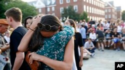 Dos personas se abrazan mientras se reúnen para una vigilia en respuesta a un tiroteo fatal en la sala de redacción de Capital Gazette, el 29 de junio de 2018, en Annapolis, Maryland, EEUU.
