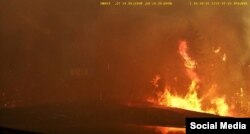 FILE - Smoke covers the road as wildfires burn in Hammonds Plains, Nova Scotia, May 28, 2023, in this screengrab obtained from a social media video.