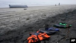 A boat sits overturned near a row of life jackets on Blacks Beach, near San Diego, California, March 12, 2023.