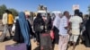 People gather at a bus stop to flee from Khartoum during clashes between the paramilitary Rapid Support Forces and the army, in Khartoum, Sudan, April 19, 2023.