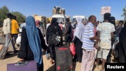 People gather at a bus stop to flee from Khartoum during clashes between the paramilitary Rapid Support Forces and the army, in Khartoum, Sudan, April 19, 2023.