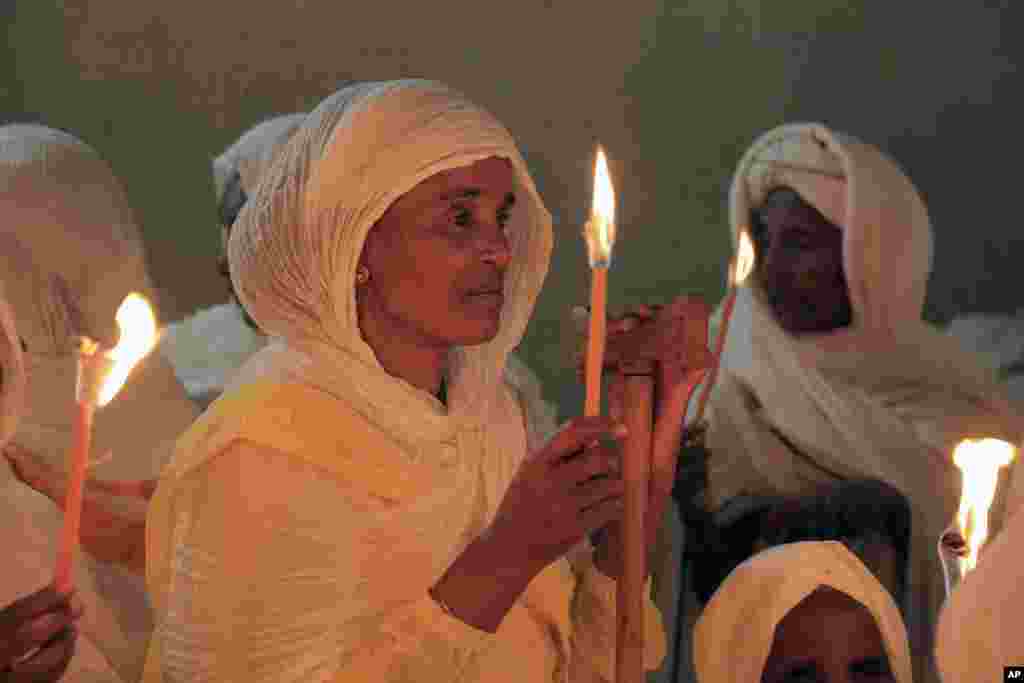 A woman holds a candle during the Orthodox Easter religious procession, in Addis Ababa, Sunday, April 16, 2023.