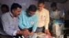 Los funcionarios electorales revisan y sellan una máquina de votación electrónica antes de permitir que los votantes emitan sus votos en un colegio electoral durante la última ronda de una elección nacional de seis semanas cerca de Dharamshala, India, el 1 de junio de 2024.
