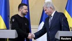 El presidente de Ucrania, Volodymyr Zelenskyy, se da la mano con el presidente de Finlandia, Sauli Niinisto, durante una conferencia de prensa conjunta en el Palacio Presidencial de Helsinki, Finlandia, el 3 de mayo de 2023.