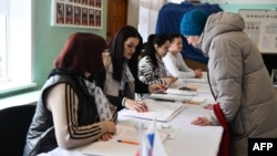 A woman registers to vote in Russia's presidential election at a polling station in Donetsk, Russian-controlled Ukraine, amid the Russia-Ukraine conflict on March 16, 2024.