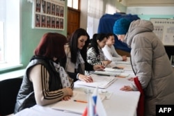 A woman registers to vote in Russia's presidential election at a polling station in Donetsk, Russian-controlled Ukraine, March 16, 2024.