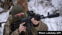 Members of the pro-Ukrainian Russian ethnic Siberian Battalion practice at a military training close to Kyiv, Ukraine, Wednesday, Dec. 13, 2023. (AP Photo/Efrem Lukatsky)
