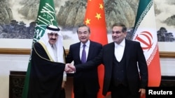 Chinese diplomat Wang Yi, center, poses with Ali Shamkhani, secretary of Iran’s Supreme National Security Council, right, and Musaad bin Mohammed Al Aiban, Saudia Arabia's national security adviser, in Beijing, March 10, 2023. (China Daily via Reuters) 