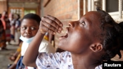 FILE - Eliza Tangwe, 18, takes a dose of oral cholera vaccine at a health center in response to the latest cholera outbreak in Blantyre, Malawi, Nov. 16, 2022.