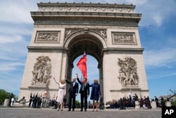 Prva dama SAD-a Jill Biden, američki predsjednik Joe Biden, francuski predsjednik Emmanuel Macron i Macronova supruga Brigitte Macron mašu tokom ceremonije u Trijumfalnoj kapiji u Parizu, 8. juna 2024.