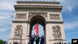 O Presidente francês Emmanuel Macron e a sua mulher Brigitte Macron e o Presidente dos EUA Joe Biden e a sua mulher Jill Biden assistem a uma cerimónia no Arco do Triunfo, em Paris, França, a 8 de junho de 2024.
