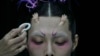 A model for the Dieyingchongchong collections by Chinese designer Dong Yaer has final makeup applied backstage during the China Fashion Week in Beijing, March 28, 2023.