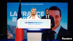French far-right leaders Marine Le Pen, left, and Jordan Bardella address supporters after the polls closed during the European Parliament elections, in Paris, France, June 9, 2024.