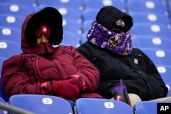 Fans watch teams warm up before an NFL football AFC divisional playoff game between the Baltimore Ravens and the Houston Texans, Jan. 20, 2024, in Baltimore.