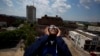 Justin Coleman, iz Birminghama, Ala., drži naočare na očima dok gleda pomračenje Sunca na vrhu parkinga, 21. avgusta 2017. u Birminghamu.