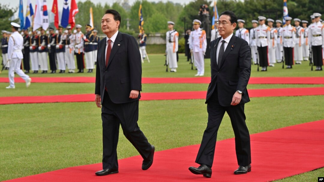Japanese Prime Minister Fumio Kishida, right, and South Korean President Yoon Suk Yeol attend a welcoming ceremony at the presidential office in Seoul, May 7, 2023. 
