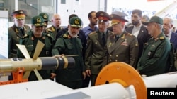 Russian Defense Minister Sergei Shoigu listens to Amirali Hajizadeh, commander of the Islamic Revolutionary Guard Corps' Aerospace Force, as they visit an aerospace industry exhibit in Tehran, Iran, Sept. 20, 2023. (Russian Defense Ministry via Reuters)