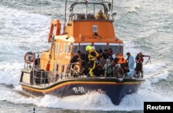 FILE—Rescue personnel bring migrants ashore after their boat sunk in the English Channel, near Dover, Britain, Augustr 12, 2023.