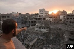 Seorang warga Palestina menunjuk ke Masjid Ahmed Yassin, yang rata dengan tanah akibat serangan udara Israel, di Kota Gaza pada 9 Oktober 2023. (Foto: AFP)