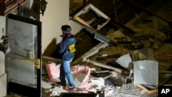 An official surveys an area near the back entrance to the Sandman Signature hotel following an explosion, Jan. 8, 2024, in Fort Worth, Texas.