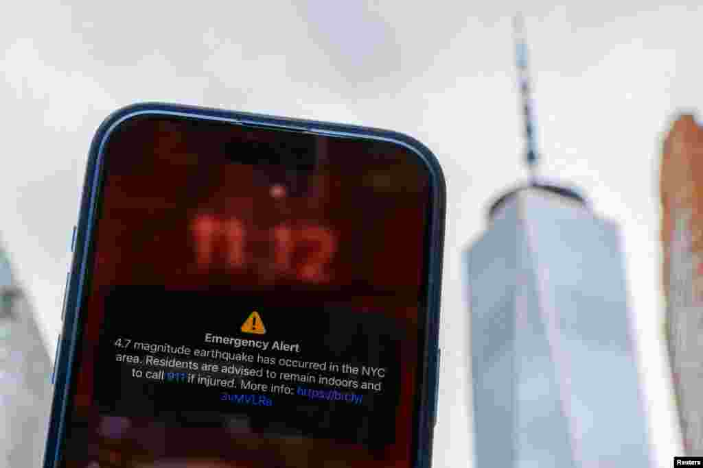 A photo illustration shows an emergency alert of a magnitude 4.7 earthquake on a cellphone in New York City.