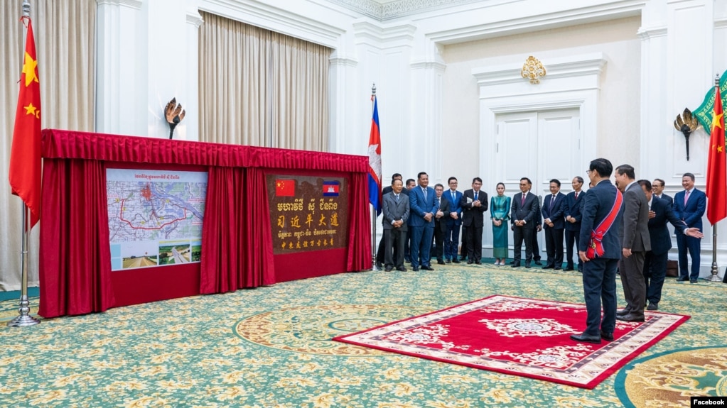 នាយករដ្ឋមន្ត្រីកម្ពុជាលោក ហ៊ុន ម៉ាណែត និងអគ្គរដ្ឋទូតចិនប្រចាំកម្ពុជាលោក Wang Wentian ឈរ​ក្នុងពិធី​សម្ពោធជានិមិត្តរូបក្នុងការប្រសិទ្ធនាមផ្លូវ «មហាវិថី ស៊ី ជីនពីង» រាជធានីភ្នំពេះ កាលពីថ្ងៃទី ២៨ ខែឧសភា ឆ្នាំ២០២៤។ (Facebook / Chinese Embassy in Cambodia)