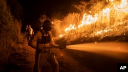 A firefighter works to contain wildfires in Nogales, in Veracruz state, Mexico, March 25, 2024.