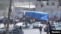 Люди біжать за вантажівкою із гуманітарною допомогою у Газі, 9 квітня 2024. 