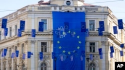Bendera raksasa Uni Eropa digantung di sebuah gedung, dan bendera-bendera yang lebih kecil menghiasi jalan utama di Sarajevo, Bosnia, 21 Maret 2024. (AP/Eldar Emric)